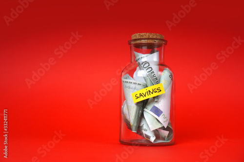 Money savings in euro concept with glass jar full of money.
