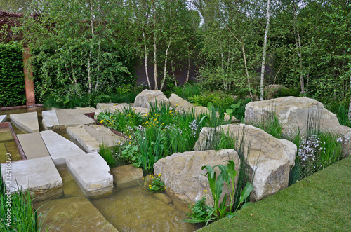 Unusual large rocks used in an urban garden design with inserted flowers and plants
