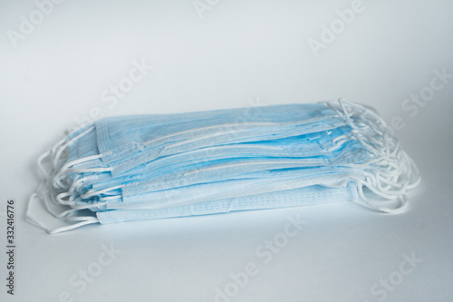 medical face masks for the prevention of coronavirus covid-19 2019-ncov on a white background. a lot of blue medical face masks. Bright minimalistic photo