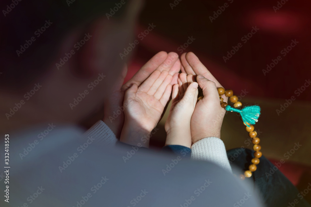 Muslim father and son praying together. Muslim dad and son praying in the mosque.
