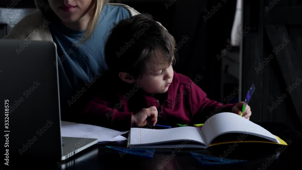 young mother works at a computer at home with her child young mother works at a computer at home with her child