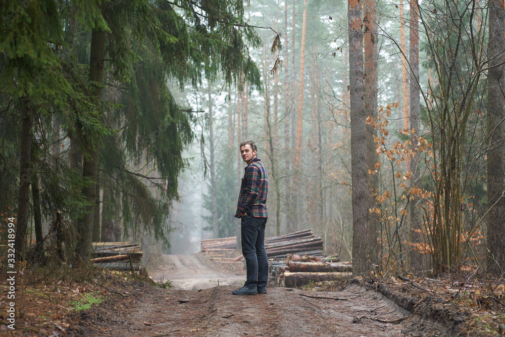 Fototapeta premium Caucasian man has a walk in foggy forest