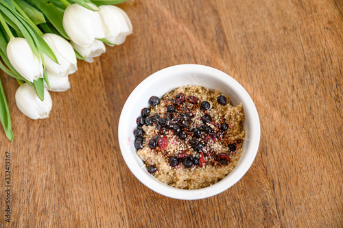 Fresh spring oatmeal  quinoa  healthy breakfast on wooden table.