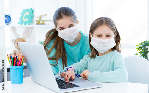 Girls studying at home using laptop during coronavirus pandemic