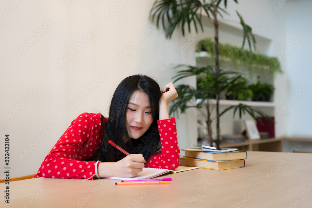 Close-up of female students taking notes on the notebook. Close-up of female students taking notes on the notebook.