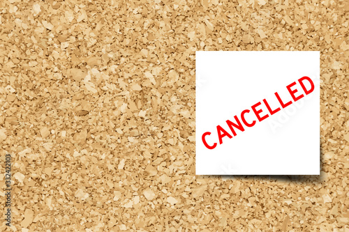 White note with word cancelled on cork board background with copy space (Vector)