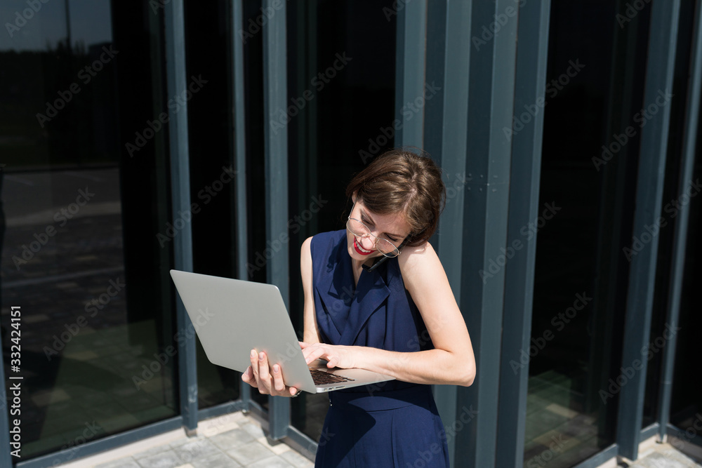 Female in office suit made an appointment and stands with laptop outside Female in office suit made an appointment and stands with laptop outside