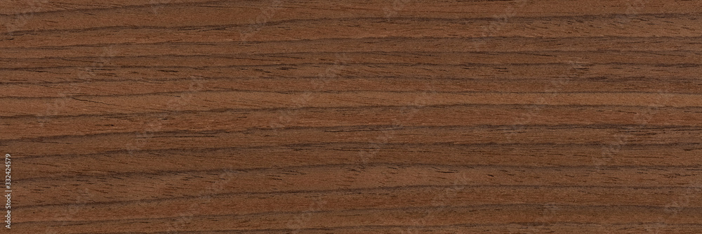 Natural dark brown nut veneer background as part of your design. Natural wood texture, pattern of a long veneer. Natural dark brown nut veneer background as part of your design. Natural wood texture, pattern of a long veneer.
