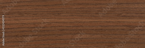 Natural dark brown nut veneer background as part of your design. Natural wood texture, pattern of a long veneer.
