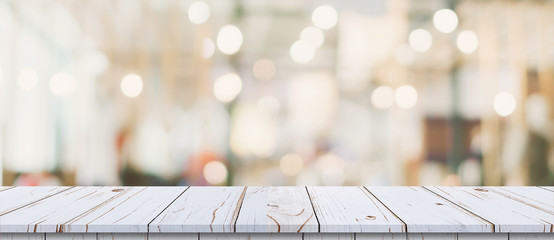 Empty wood table and blurred light table in shopping mall with bokeh background. product display template.