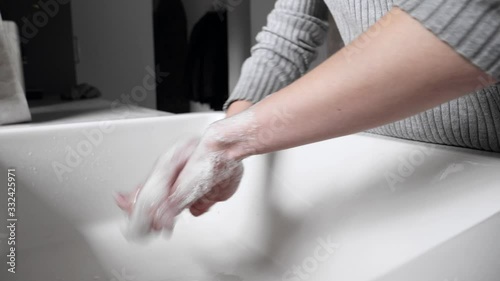 Woman washing hands in kitchen at home, video