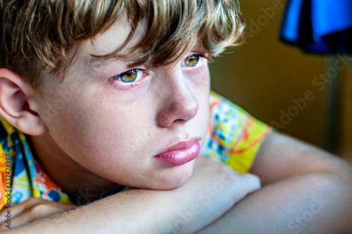 Fotografie Profile of a sad crying boy with a tear on his cheek