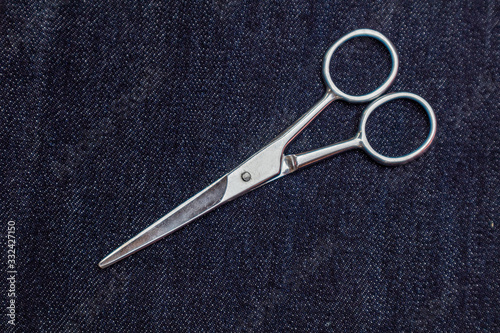 Scissors on a blue denim background.