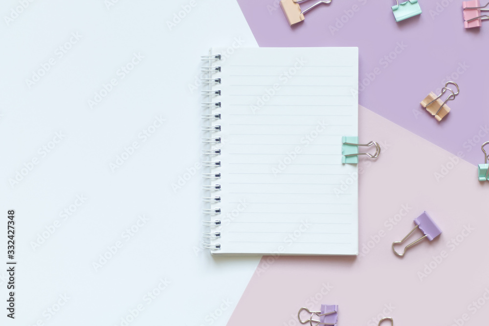 white Notepad with springs on a white and lilac background with purple delicate clips white Notepad with springs on a white and lilac background with purple delicate clips