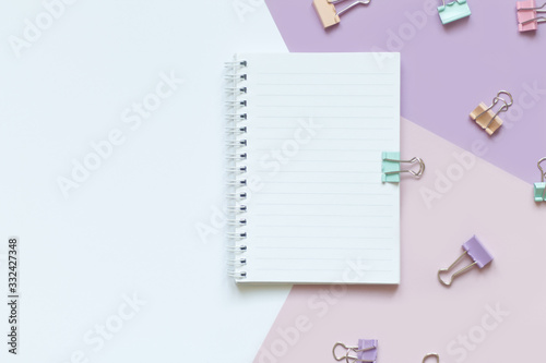 white Notepad with springs on a white and lilac background with purple delicate clips