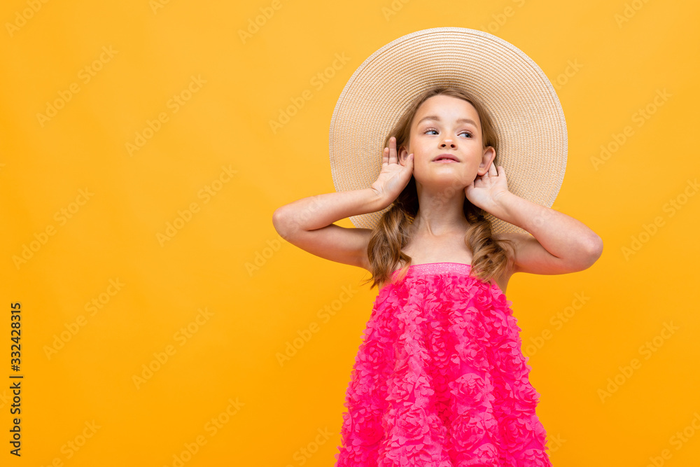 stylish teenager girl in a pink blouse with a straw hat on her head on a yellow studio background stylish teenager girl in a pink blouse with a straw hat on her head on a yellow studio background