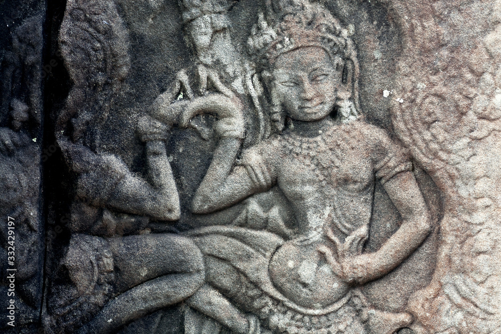 Dancing woman on 12th century ruined relief of the Bayon temple, Cambodia. Historical artwork on column of Khmer landmark in Angkor. UNESCO world heritage site