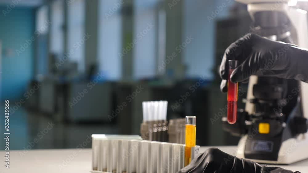 Close-up shot of female Hand of researcher in Glove Using Micro Pipette while Working with Test Tubes. People in Innovative Pharmaceutical Laboratory with Modern Medical Equipment for Genetics Close-up shot of female Hand of researcher in Glove Using Micro Pipette while Working with Test Tubes. People in Innovative Pharmaceutical Laboratory with Modern Medical Equipment for Genetics