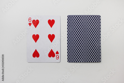 Six of hearts playing card with deck isolated on white. Playing cards image with 6 hearts laying on empty white table photo