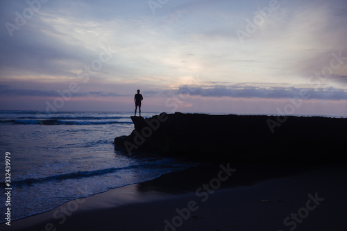 Menschen auf felsen am Strand bei sonnenuntergang 