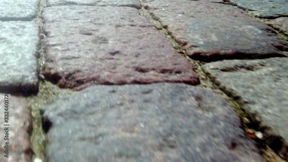 ancient cobblestone street, close-up of rectangular various colors of granite bricks ancient cobblestone street, close-up of rectangular various colors of granite bricks
