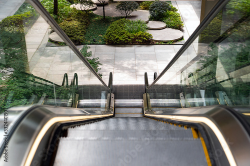 Fototapeta Naklejka Na Ścianę i Meble -  Escalator Going Down to the Green Sunken Plaza.