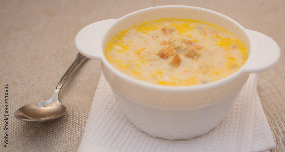 Puree soup with cheese in a white ceramic bowl on a white napkin. Puree soup with cheese in a white ceramic bowl on a white napkin.