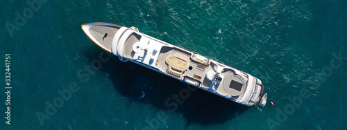 Aerial drone ultra wide top down photo luxury mega yacht with wooden deck anchored in Aegean deep blue sea