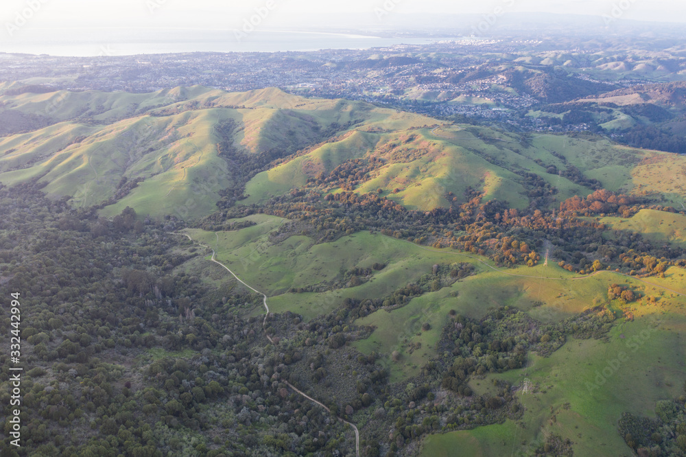 Evening sunlight shines on the green hills of the East Bay in Northern California. This open area, east of San Francisco Bay, is green in the winter due to rain and golden during the summer.