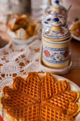 SKUDENESHAVN, NORWAY - 2016 FEBRUARY 26. Typical homemade stroopwafel of Norway, with classy porcelain settings in the background.