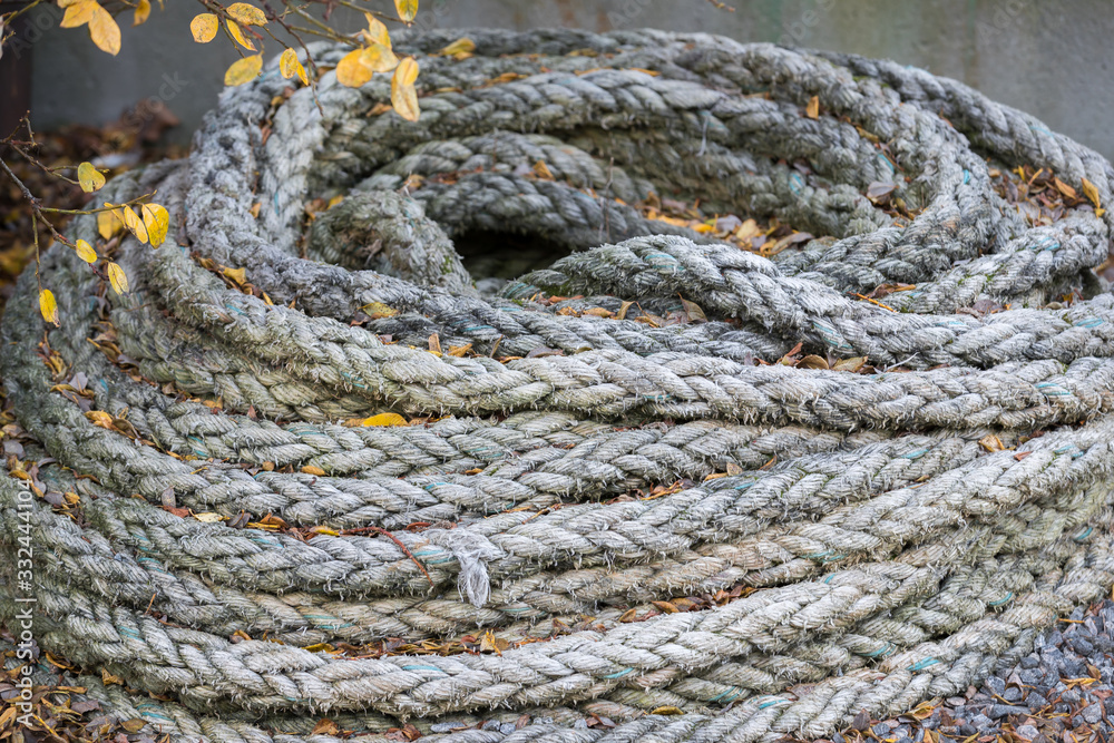 Old grey mooring rope with orange autumn leafs. Old grey mooring rope with orange autumn leafs.