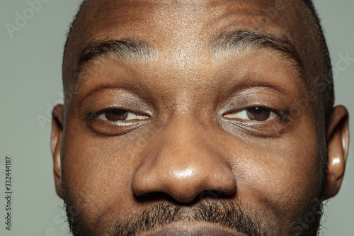 Delighted. Close up of face of beautiful african-american young man, focus on eyes. Human emotions, facial expression, cosmetology, body and skin care concept. Well kept skin. Wellbeing.