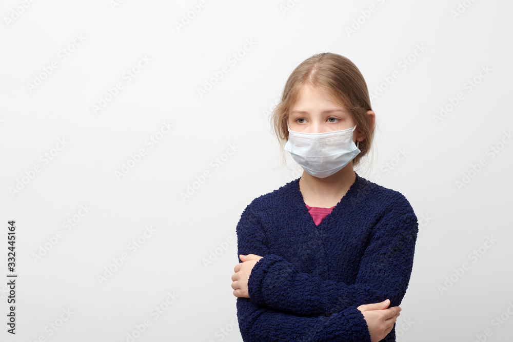 Young girl wearing face mask and hugging herself looking aside Young girl wearing face mask and hugging herself looking aside