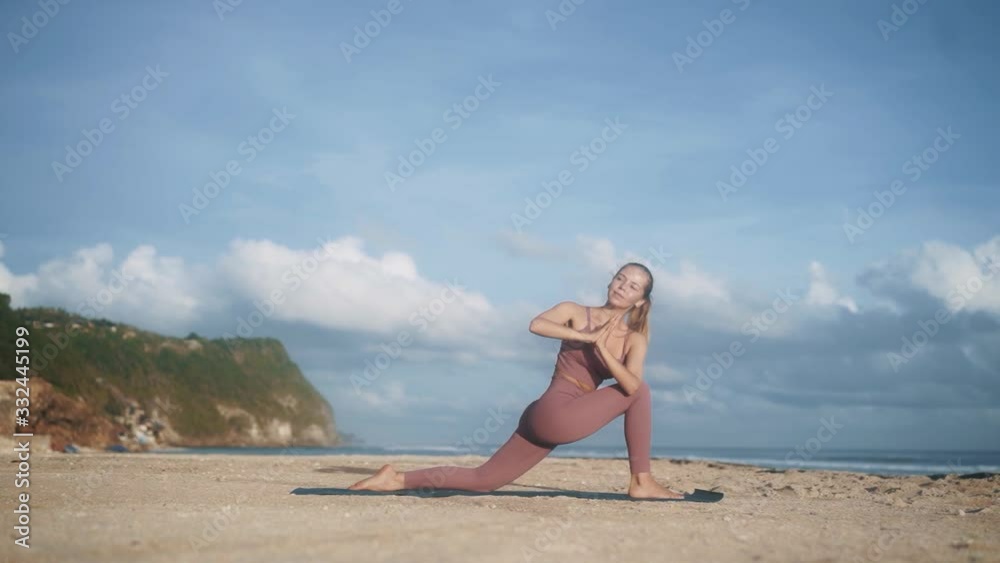 woman in violet tracksuit does yoga pose stretching arms woman in violet tracksuit does yoga pose stretching arms