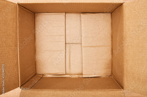 Inside open empty corrugated brown cardboard box. Top down shot. Blank space