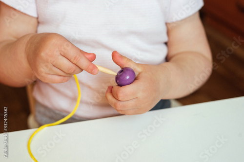 Konstfotografi Child putting beads on a string
