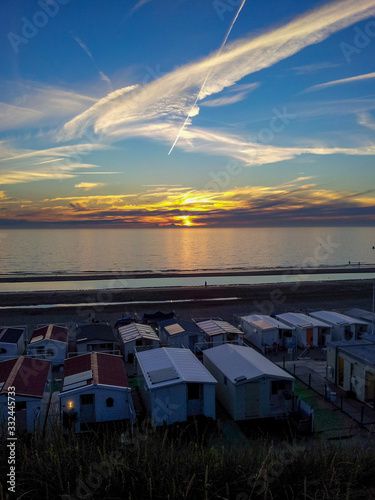 Scenic view of sunset at beach with bungalows in Zandvoort, Netherlands