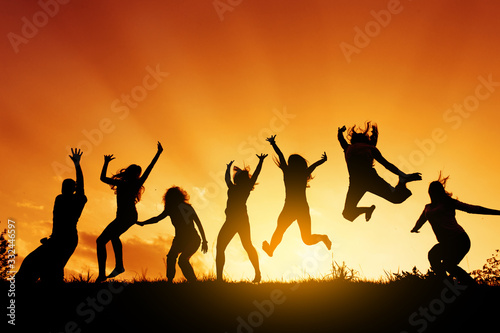 Group of people jumping against the sunset