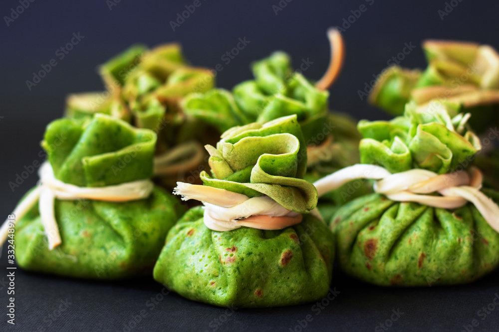 Spinach pancakes with meat filling on dark background. Spinach pancakes with meat filling on dark background.