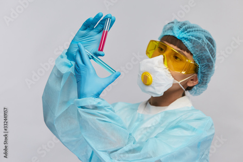 biochemist analysing two twst tubes with different liquids of blue and red colors in protection glasses photo