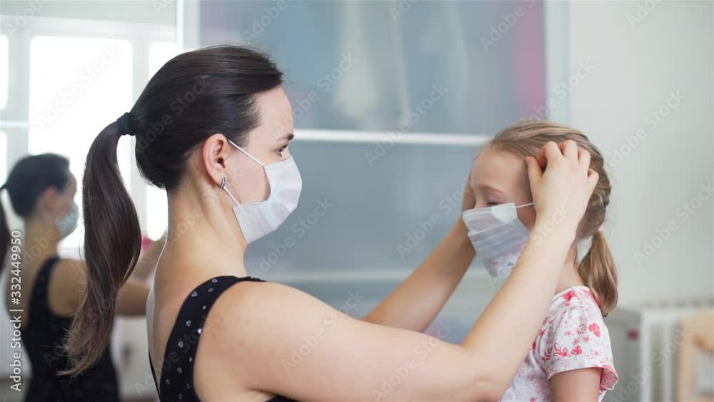 Mother Putting on a Medical Protective Mask on her Cute Child Daughter. Healthcare and Sickness Prevention from Coronavirus, Covid19 influenza Mother Putting on a Medical Protective Mask on her Cute Child Daughter. Healthcare and Sickness Prevention from Coronavirus, Covid19 influenza