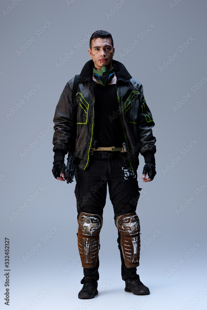 handsome bi-racial cyberpunk player standing on grey