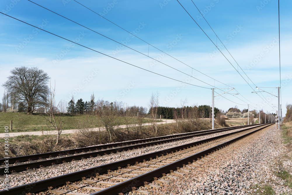 Double electrified railroad tracks in early spring going from left to right