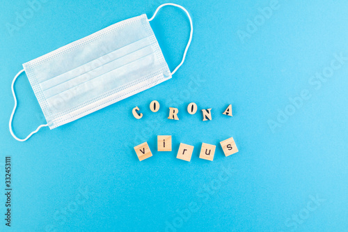 The inscription Coronavirus laid out of wooden cubes on a blue background.
