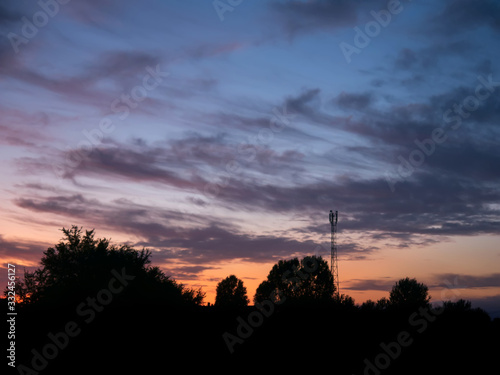 view over a beautiful sunset behind a radio antenna tower.