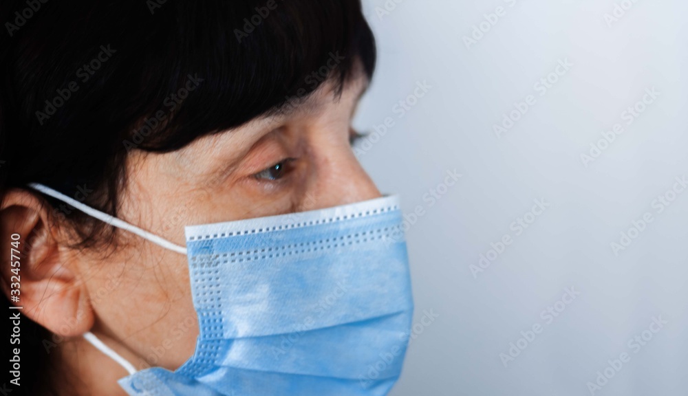 Coronavirus quarantine and Air pollution pm2.5 concept. Face of old sick woman wearing blue respirator mask for protect. Wuhan, China epidemic virus symptoms background. Coronavirus quarantine and Air pollution pm2.5 concept. Face of old sick woman wearing blue respirator mask for protect. Wuhan, China epidemic virus symptoms background.