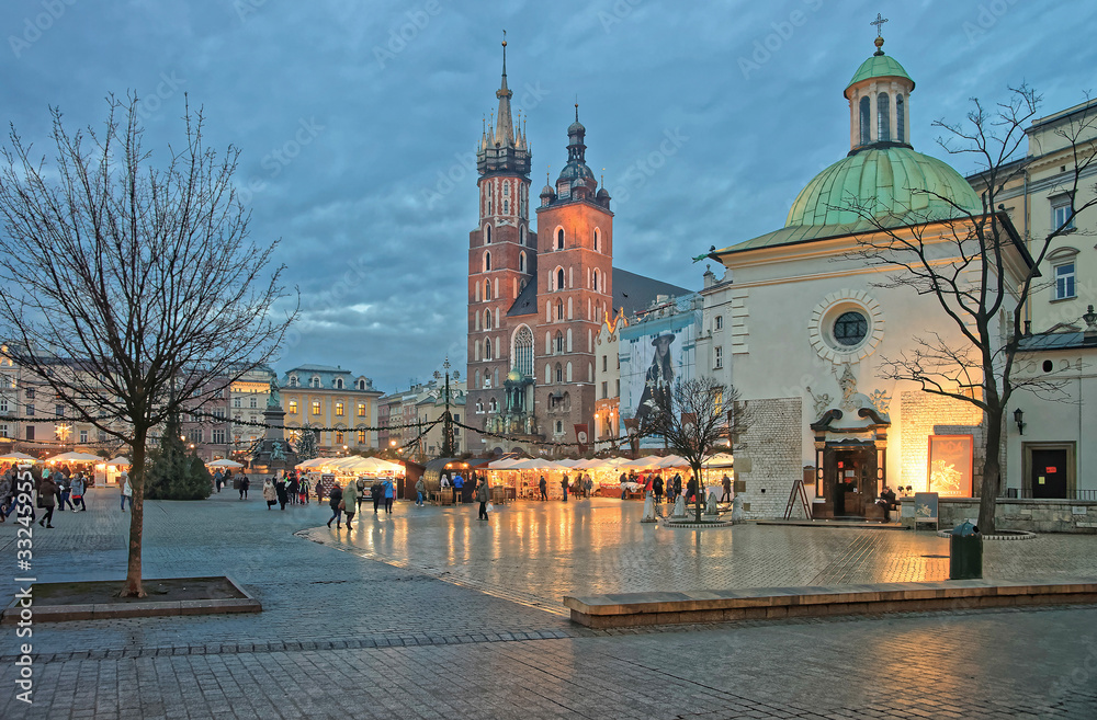 Fototapeta premium Church of St Wojciech and St Mary Basilica in the Main Market Square of the Old City in Krakow in Poland at Christmas