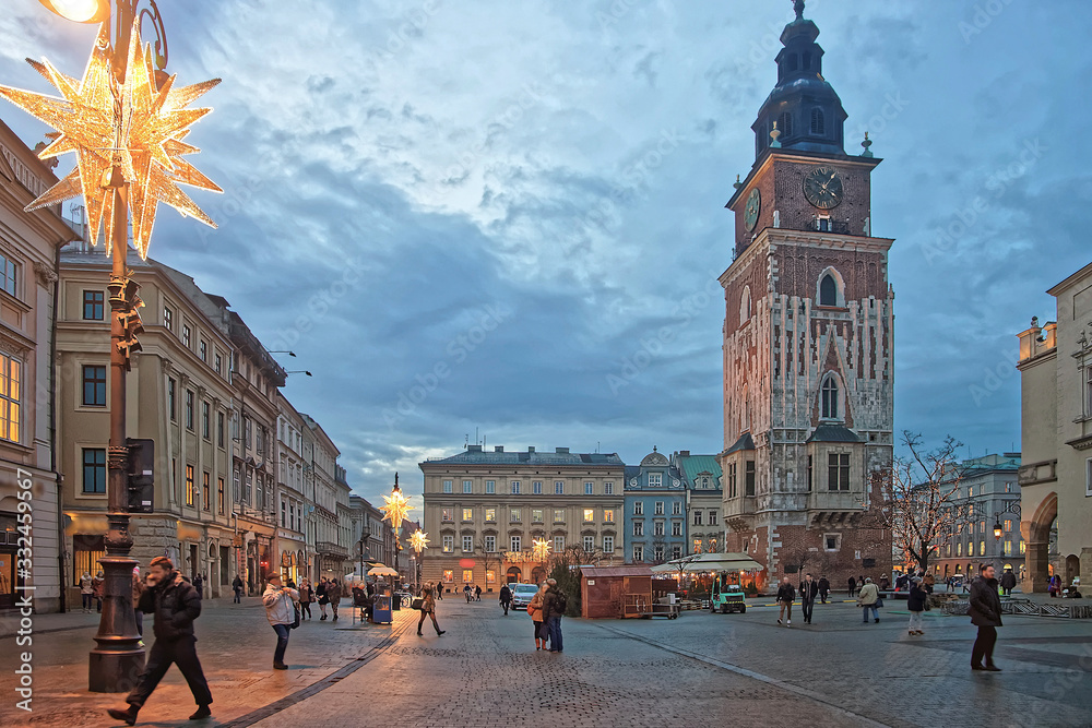 Naklejka premium Town Hall Tower and the street market in the Main Market Square of the Old City in Krakow in Poland at Christmas