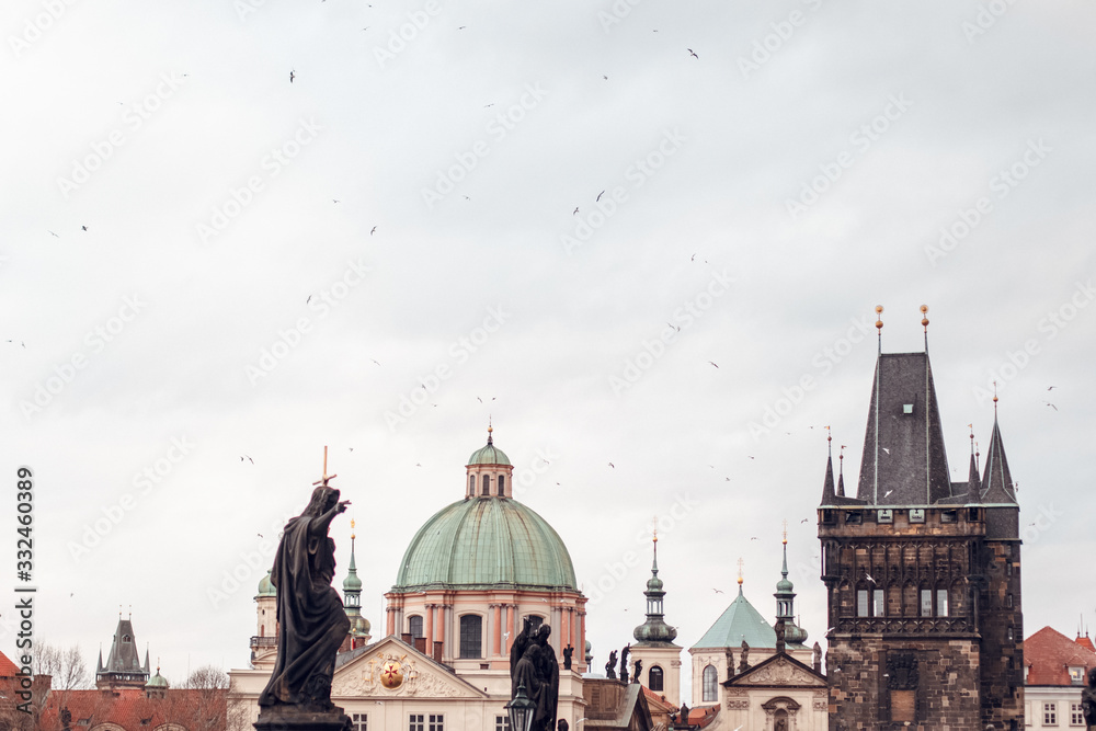 view of cathedral and tower on the Charles Bridge with flying seagulls