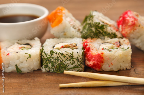 Set of rolls with dill and salmon with soy sauce and chopsticks.